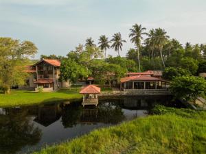 una casa junto a un río con un puente en Malala Retreat, en Hambantota