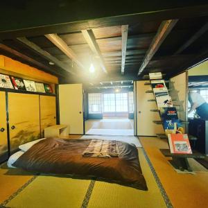 um quarto com uma cama grande no meio em ゲストハウス　にじゅうよん em Sakashita