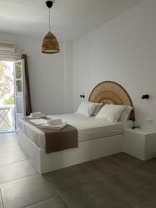um quarto branco com uma cama grande e uma janela em Maria's Garden em Andiparos