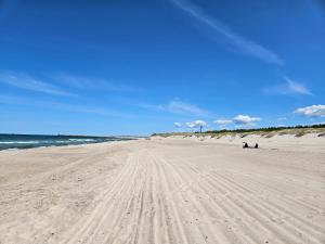 ウストカにある8Apartmentの砂浜と海の足跡がある海岸