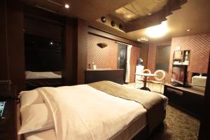 a hotel room with a large bed and a bathroom at ホテルロペ39 大人専用 in Nagoya