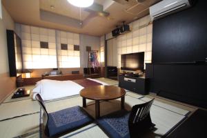 a bedroom with a bed and a table and chairs at ホテルロペ39 大人専用 in Nagoya