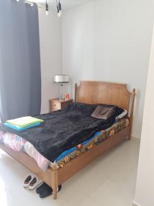 brand new villa في دبي: سرير مع لحاف أسود وأحذية عليه