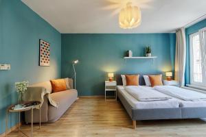 Dormitorio azul con cama y sofá en Central, modern city apartments - by homekeepers, en Würzburg