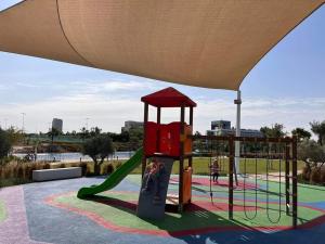 brand new villa في دبي: ملعب مع زحليقة في حديقة