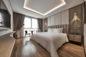 La Siesta Premium Saigon في مدينة هوشي منه: غرفة فندقية بسرير كبير وطاولة