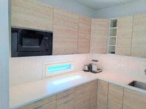 a kitchen with a sink and a microwave at Saunallinen kaksio ilmastoinnilla ja autopaikalla! in Oulu