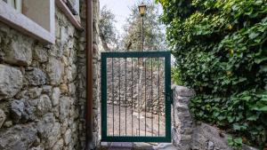 une porte dans un mur en pierre avec un portail dans l'établissement Appartamenti Albatros, à Brenzone