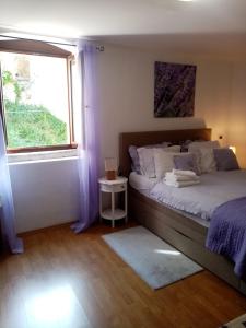 a bedroom with a large bed and a window at Rooms Serafin-Lavanda in Motovun