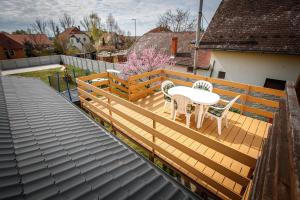 a wooden deck with a table and chairs on it at Olivia Apartment House in Balatonboglár