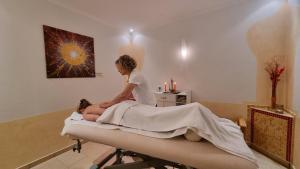 a woman sitting on a bed in a room at Seehotel Hubertus in Schluchsee