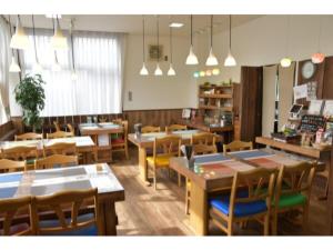 un restaurante con mesas de madera, sillas y luces en Fujieda Ogawa Hotel - Vacation STAY 20873v en Fujieda