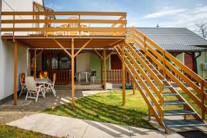 a wooden pergola with a table and chairs in a yard at Olivia Apartment House in Balatonboglár