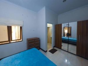 a bedroom with a blue bed and a mirror at Sukasari Guesthouse in Tasikmalaya