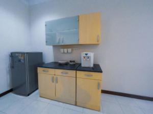 a kitchen with wooden cabinets and a refrigerator at Sukasari Guesthouse in Tasikmalaya
