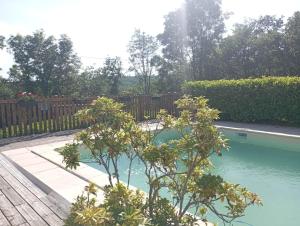 una piscina en un patio con una valla de madera en Gîtes Périgord Rocamadour Sarlat Gourdon naturiste de juin à sept, en Salviac