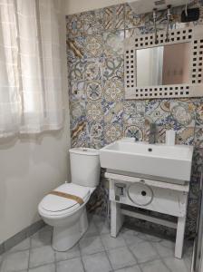 a bathroom with a toilet and a sink and a mirror at Al Settimo porta marina in Siracusa