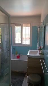 a bathroom with a sink and a tub and a window at Grand Duplex DANS villa familiale 3CH 7 PERS JARDIN, PISCINE in Juvignac