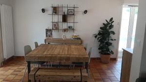 a dining room with a wooden table and chairs at Grand Duplex DANS villa familiale 3CH 7 PERS JARDIN, PISCINE in Juvignac