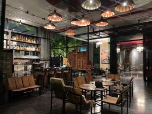 un restaurante con mesas, sillas y luces en Sibtis Hotel en Lampang