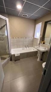 uma casa de banho com uma banheira e um lavatório em Mountainview Inn em Harrismith