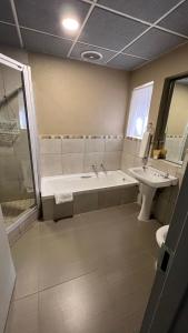 a bathroom with a tub and a sink at Mountainview Inn in Harrismith