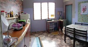 a kitchen with a counter and a table and a window at Homestay D'Hiburan Kuala Rompin in Kuala Rompin