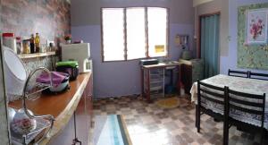 cocina con encimera, mesa y ventana en Homestay D'Hiburan Kuala Rompin, en Kuala Rompin