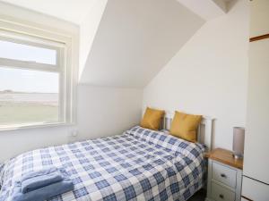 a bedroom with a bed and a window at Pow-Wow Shore Cottage in Annan