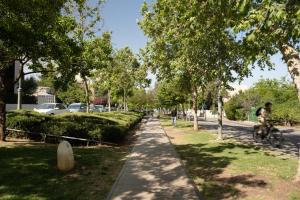 una acera en un parque con gente montando bicicletas en THE Y HOUSE, en Jerusalén