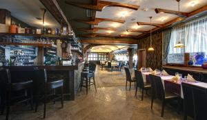a restaurant with tables and chairs and a bar at Hotel Galileo Donovaly in Donovaly
