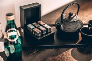 a table with a tea kettle and a bottle of water at Benjamin Business Hotel in Herzelia 