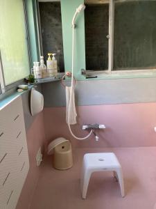 een roze badkamer met een toilet en een wastafel bij ＯＫＵＮＯ ＩＥ in Oshima