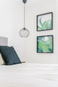 a bedroom with a bed with two pictures on the wall at Moott Homes Suites Casa de los Leones APTO 2 in Almería