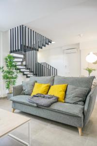 a living room with a gray couch with yellow pillows at Moott Homes Suites Casa de los Leones APTO 2 in Almería