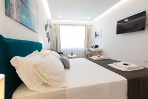 a bedroom with a large bed with white sheets and pillows at Minimal apartment in Plaka in Athens