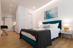 a bedroom with a large bed with a blue headboard at Minimal apartment in Plaka in Athens