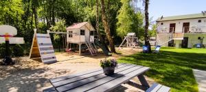 a backyard with a picnic table and a playground at Brzozowa Oaza in Mrzeżyno