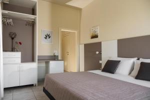 ミラノ・マリッティマにあるHotel Parcoのベッドルーム1室(大型ベッド1台、白いキャビネット付)