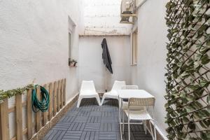 un patio con 2 sillas blancas y una mesa en Acogedor y moderno - 1Dormitorio 1Baño - Imperial en Madrid