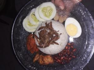a plate of food with rice and eggs and beans at OM Homestay in Bentota