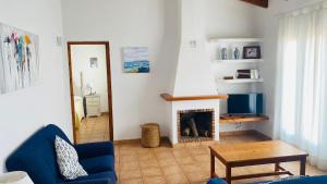 a living room with a blue couch and a fireplace at Villa Áncora in Binibeca