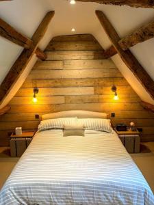ein Schlafzimmer mit einem großen Bett im Dachgeschoss in der Unterkunft Cotswold Cottage- Central Witney in Witney