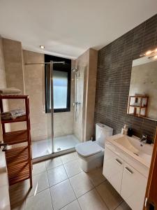 uma casa de banho com um chuveiro, um WC e um lavatório. em Apartamentos TDM em Tossa de Mar