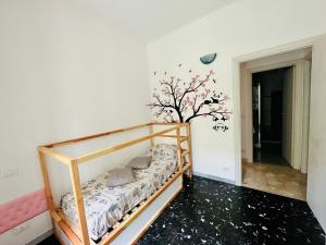 ein Schlafzimmer mit einem Bett und einem Baum an der Wand in der Unterkunft Casa Mirosa in Arenzano
