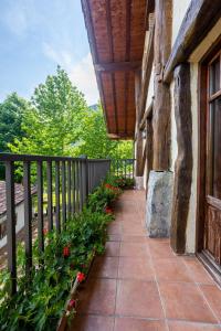 a porch of a house with a fence and flowers at Baserri Forua by Urdaibai Rentals in Forua