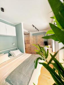 um quarto com uma cama e uma planta em Oniro Suite em Belgrado