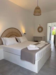 sypialnia z dużym białym łóżkiem z ręcznikami w obiekcie Maria's Garden w mieście Andiparos