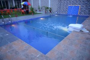 a swimming pool with blue water and an umbrella at Grand Resort in Puri