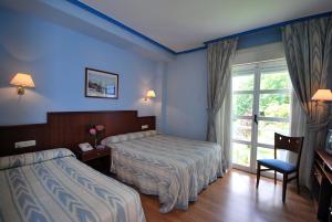 a hotel room with two beds and a window at Vega Del Sella in Arriondas +65 photos